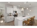 Bright kitchen features white cabinets, stainless steel appliances, and a spacious island with seating at 1515 Tamarisk Ln, Durham, NC 27703