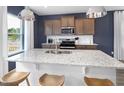 Stylish kitchen with granite counters, stainless appliances, and pendant lighting over the island at 1517 Tamarisk Ln, Durham, NC 27703