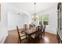 Bright dining room featuring hardwood floors, wainscoting, and a traditional chandelier, perfect for formal dining at 1720 Laurel Park Pl, Cary, NC 27511