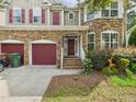 Beautiful two-story house featuring a stone facade, red shutters, brick steps, and two-car garage at 1728 Callandale Ave, Cary, NC 27518