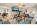 Cozy living room with hardwood floors, ceiling fan, large mounted TV and view to dining room at 1905 Bivins St, Durham, NC 27707