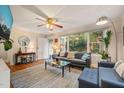 Bright living room featuring hardwood floors, ceiling fan, large window and an accent rug at 1905 Bivins St, Durham, NC 27707