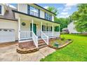 Charming home with a welcoming front porch, brick stairs, and manicured landscaping at 212 Spearhead Pl, Clayton, NC 27520