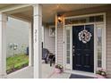 Inviting front door with decorative wreath, sidelights, and charming front porch at 215 Outwater Ridge Dr, Garner, NC 27529
