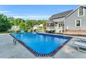 Sparkling in-ground pool with a brick trim, lounge chairs, and a screened-in porch at 227 Paraggi Ct, Clayton, NC 27527