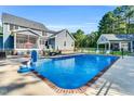 Backyard featuring a refreshing in-ground pool, patio area, and lush greenery at 227 Paraggi Ct, Clayton, NC 27527