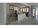 Spacious kitchen with cabinets awaiting countertops, island, and natural light from nearby windows at 256 Meadowbark Bnd # 45, Garner, NC 27529