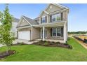 Attractive two-story home showcasing a combination of brick and siding, a two-car garage, and manicured landscaping at 304 Ford Meadows Dr, Garner, NC 27529