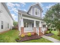 Inviting two-story home featuring a covered front porch, brick accents, and well-maintained landscaping at 307 Millbrook Dr, Pittsboro, NC 27312