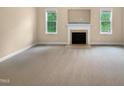 Open living room featuring a fireplace and two large windows at 3116 Kirby St, Durham, NC 27713