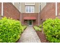 Condo entrance with brick walls, decorative landscaping, and a well-maintained walkway at 324 Waterford Lake Dr, Cary, NC 27519