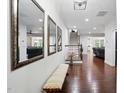 Bright foyer with hardwood floors, a bench, decorative mirrors, and a staircase at 369 Roberts Ridge Dr, Cary, NC 27513