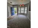 Bright living room with gray walls, plush gray carpet, stylish lighting and a blue front door at 401 Coalinga Ln # 106, Raleigh, NC 27610
