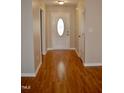Welcoming entryway featuring a decorative front door and pristine hardwood floors at 411 Joneshaven Dr, Fuquay Varina, NC 27526