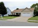 Charming single-story home with an attached garage and a spacious driveway at 411 Joneshaven Dr, Fuquay Varina, NC 27526