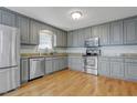 Modern kitchen featuring stainless steel appliances, gray cabinets, and granite countertops at 419 Jera Dr, Garner, NC 27529