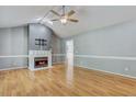Spacious living room with a cozy fireplace, wood floors, and a modern ceiling fan at 419 Jera Dr, Garner, NC 27529