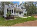 Inviting home with a classic design, featuring a covered front porch, black shutters, and a beautifully landscaped yard at 4416 Thistlehill Ct, Raleigh, NC 27616