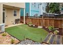 A backyard featuring artificial turf, a wood fence, and rock landscaping at 4605 All Points View Way, Raleigh, NC 27614