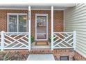 Cozy front porch with brick accents, a white railing, and a welcoming doormat at 4658 Fawnbrook Cir, Raleigh, NC 27612