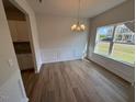 Bright dining room featuring hardwood floors, wainscoting, and a large window with neighborhood views at 48 Freedom Heights Ln # 150, Smithfield, NC 27577