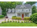 Traditional two-story home boasts lush landscaping, a covered porch, and an attached two-car garage at 5 Providence Ridge Ln, Durham, NC 27713