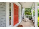 Close-up of the front porch with a bright red door and a classic white rocking chair at 5 Providence Ridge Ln, Durham, NC 27713