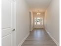 Bright hallway featuring wood-look floors and an elegant entry door at 56 Braddock Ct, Garner, NC 27529