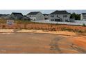Street view showcasing the neighborhood homes and available home site with visible signage at 56 Braddock Ct, Garner, NC 27529