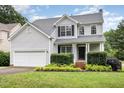 Inviting two-story home with manicured landscaping, a covered porch and an attached garage at 5637 Yates Garden Ln, Raleigh, NC 27606