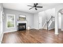Spacious living room featuring a fireplace, hardwood floors, and an open staircase at 5637 Yates Garden Ln, Raleigh, NC 27606