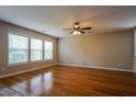 Large living room with hardwood floors, neutral walls, and plenty of natural light from the windows at 6101 Ricker Rd, Raleigh, NC 27610