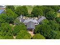 Stunning aerial view of estate home surrounded by mature trees and greenery overlooking the golf course at 6510 New Market Way, Raleigh, NC 27615