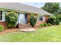Close-up of a lovely brick home's front entrance, framed by lush greenery at 816 Miller Rd, Hillsborough, NC 27278