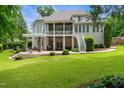 Expansive backyard featuring a covered patio, tiered landscaping, and outdoor seating area at 8405 Hempton Cross Dr, Wake Forest, NC 27587