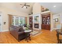 Warm living room featuring a cozy fireplace, built-in bookshelves, and large windows at 8405 Hempton Cross Dr, Wake Forest, NC 27587