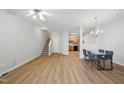 Bright living room with wood floors, a ceiling fan, stairs, and dining area that flows into the kitchen at 8621 Neuse Club Ln # 106, Raleigh, NC 27616