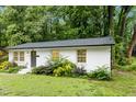 Charming, one story, white brick home, with black front door and mature trees at 117 Bertie Dr, Raleigh, NC 27610