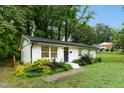 Charming, one story, white brick home, with black front door and manicured landscaping at 117 Bertie Dr, Raleigh, NC 27610