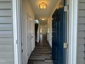 Inviting entryway featuring wood-look floors, a view of the stairs, and a stylish blue front door at 128 Bruce Dr, Dunn, NC 28334