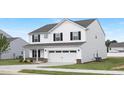Charming two-story home boasts white siding, black shutters, a two-car garage, and a nicely landscaped lawn at 140 Benson Village Dr # 83, Benson, NC 27504