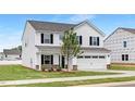 Attractive two-story house with white siding, black shutters, a two-car garage, and a well-manicured lawn at 140 Benson Village Dr # 83, Benson, NC 27504
