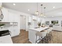 Modern kitchen featuring white cabinets, stainless steel appliances, a quartz countertop island, and pendant lighting at 140 Benson Village Dr # 83, Benson, NC 27504
