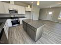 Bright kitchen featuring stainless appliances, gray countertop island, and hardwood floors at 140 Brookhaven Dr, Spring Hope, NC 27882