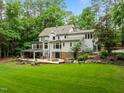 Sprawling backyard with covered patio, outdoor seating, and lush landscaping for entertaining and relaxing at 1501 Chatsworth Ln, Raleigh, NC 27614