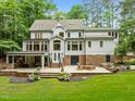 Back of home view showing outdoor entertainment space with seating, grilling area, and manicured lawn at 1501 Chatsworth Ln, Raleigh, NC 27614