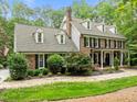 Beautiful brick home with shutters, dormer windows, professional landscaping, and an American flag in the driveway at 1501 Chatsworth Ln, Raleigh, NC 27614