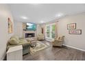 Cozy living room featuring a stone fireplace, hardwood floors, and large windows that flood the space with natural light at 151 Lake Pine Dr, Cary, NC 27511