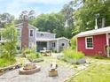 Charming backyard featuring a fire pit, raised garden beds, and a cozy covered patio with outdoor seating at 183 Birnamwood Dr, Chapel Hill, NC 27516