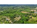 Expansive aerial view showcases a private estate nestled among lush trees, offering seclusion and natural beauty at 1852 Gwyn Rd, Burlington, NC 27217